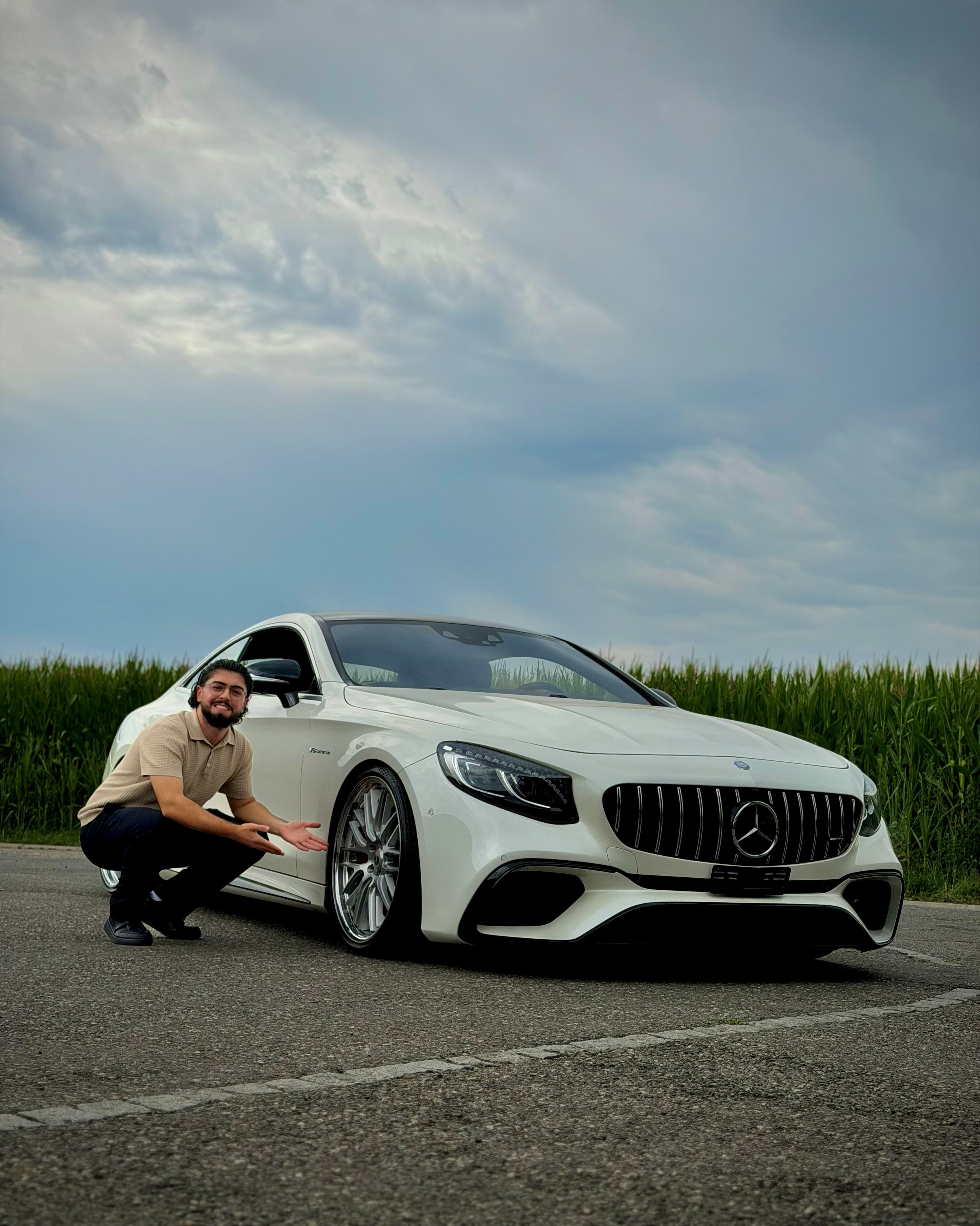 Riwan crouched beside the Mercedes-AMG S63 Coupé